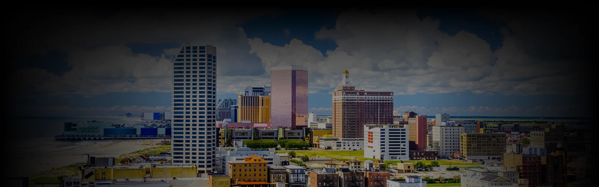 Daytime skyline shot of Atlantic City's modern high-rises under a blue sky, symbolizing the destination for Philadelphia to Atlantic City Car Service in a front-facing urban view.