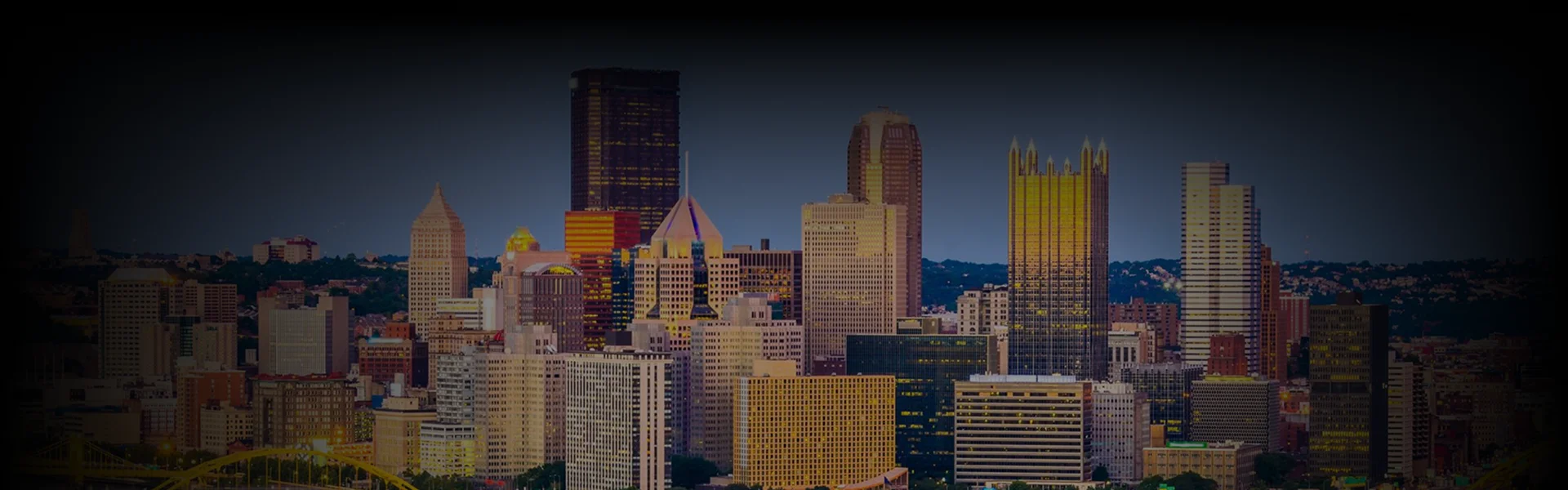 Pennsylvania Car Service with a wide-angle view of Pittsburgh's city skyline glowing in twilight.